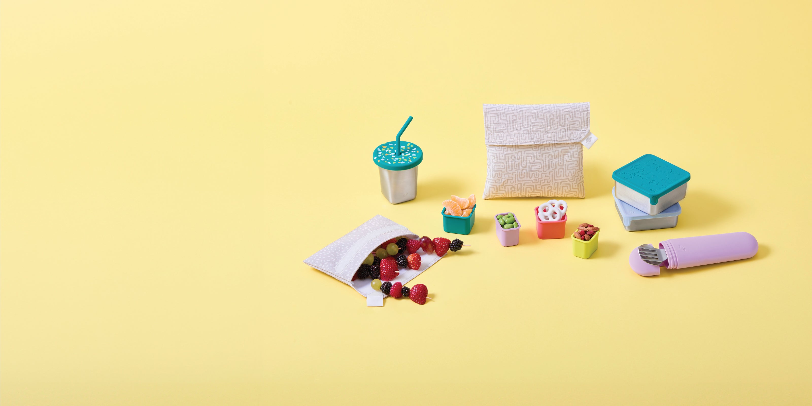 PlanetBox Accessories assortment including snack packs and dig-in utensil on yellow background.