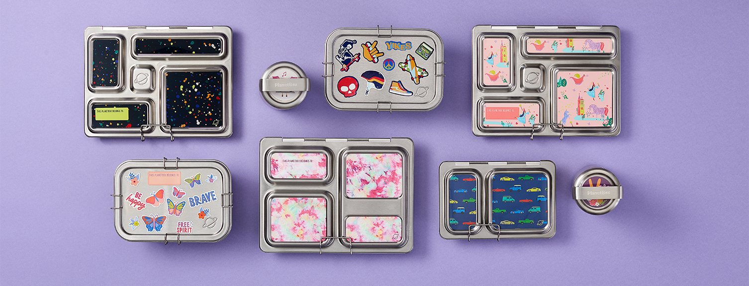 Assortment of on different lunchboxes on purple background. Inludes: butterflies mix and match magnet, traffic jam car themed magnet, splatter paint magnet, fairytale fantasy magnets.