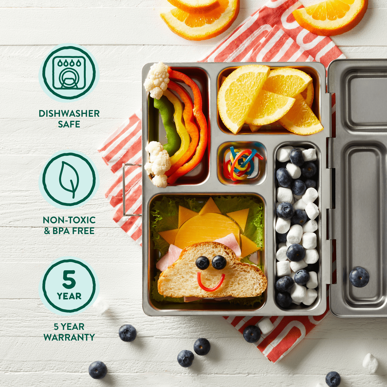 Infographic for Rover. Text: Dishwasher safe with dishwasher icon, Non-toxic and BPA-Free with leaf icon. 5 Year Warranty with number 5 icon. Open view of playful packed rover, includes sandwich in shape of cloud, rainbow peppers and cauliflower clouds, orange slices, blueberries and marshmallow with candy,