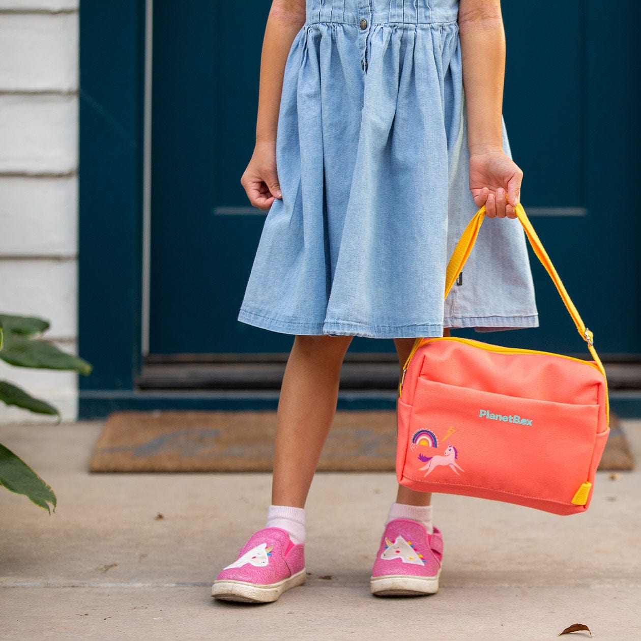 Young girl holding Small Carry Bag by the straps.