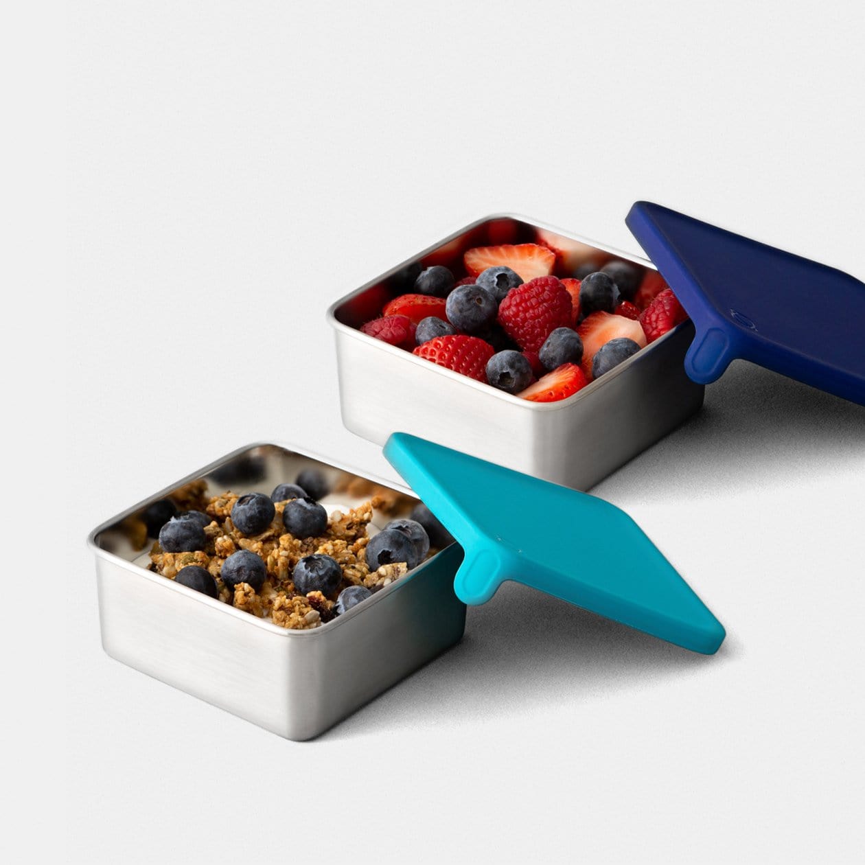 Big Square Dipper with Navy lid, and Teal lid side by side filled with fruit and granola.