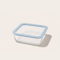 Square glass storage container with light blue lid on a kitchen counter