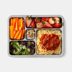 Top down shot of plated rover tray. Clockwise: Carrot sticks, strawberries, Spaghetti with red sauce, salad, and pistachios in small treat compartment. 