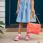 Young girl holding Small Carry Bag by the straps.