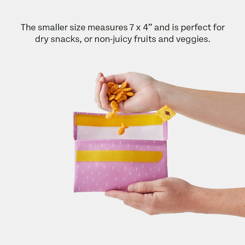 PlanetBox Snack Pack sets in Blossom and Snap Pea displayed on a table with snacks.